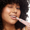 lip service woman using balm to gloss lip hydrating